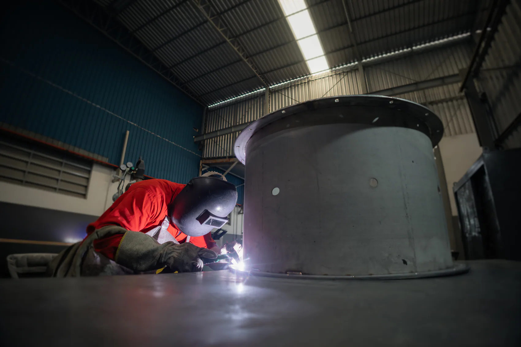 Profissional realizando soldagem em um equipamento industrial